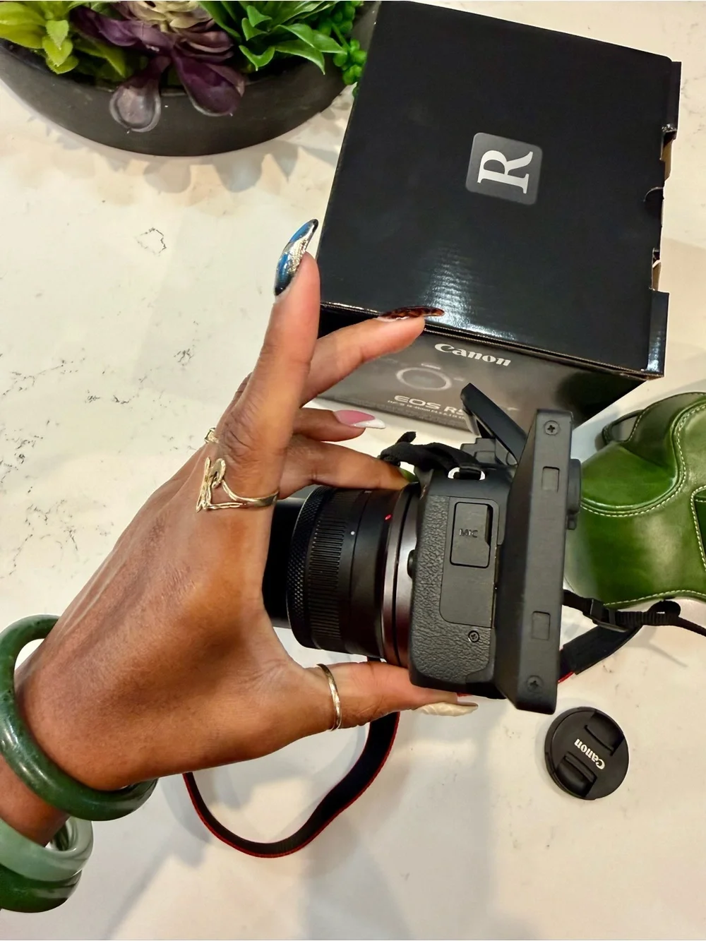 Canon EOS R50 Black Mirrorless Camera with Red-Trim Strap and Green Case
